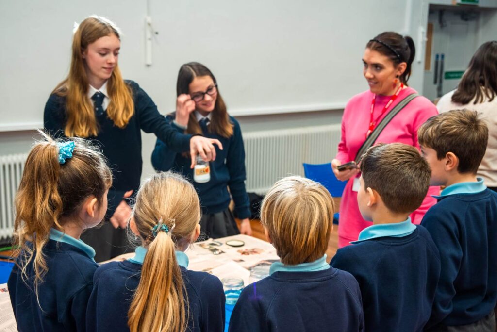 Older children show primary school children a science experiment